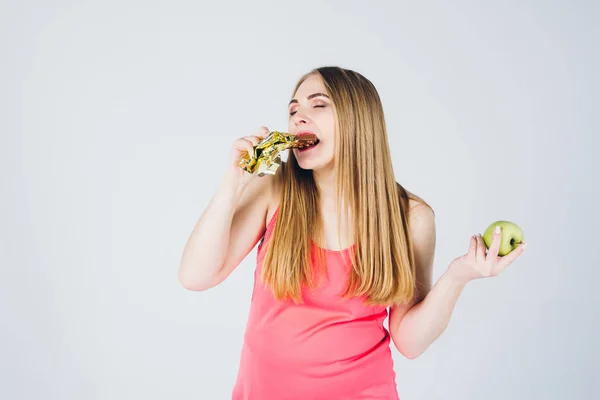 Chica elige entre manzana y chocolate — Foto de Stock
