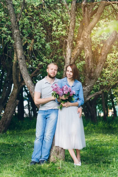 Verliebte Paare ruhen sich im sommerlichen Apfelgarten aus — Stockfoto