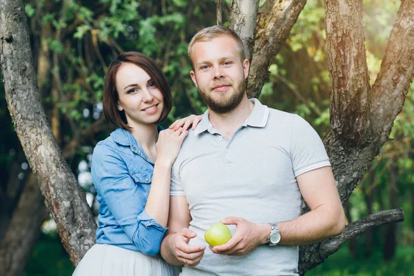 Casal apaixonado tem um resto no verão pomar de Apple — Fotografia de Stock