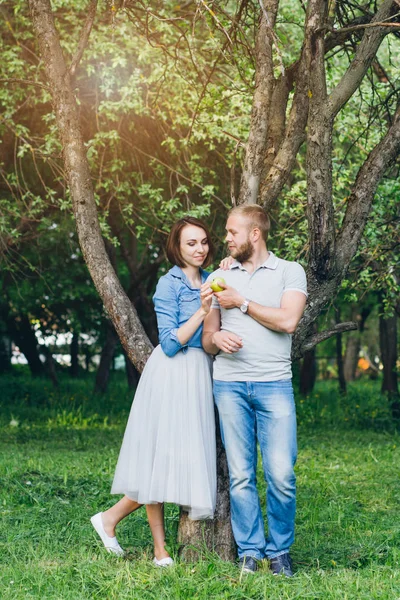 Casal apaixonado tem um resto no verão pomar de Apple — Fotografia de Stock