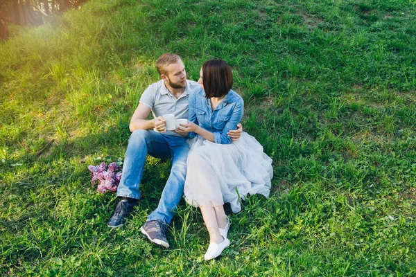 Casal apaixonado tem um resto no verão pomar de Apple — Fotografia de Stock