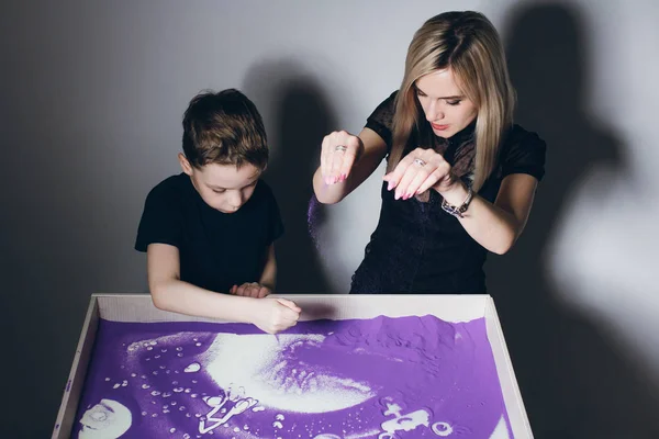 Mujer y un niño dibujan en una mesa de arena interactiva —  Fotos de Stock