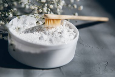 Gri arka planda doğal bambu diş fırçaları ve diş pudrası. Çevre dostu yaşam tarzı kavramı. Tonlama. Seçici odak.