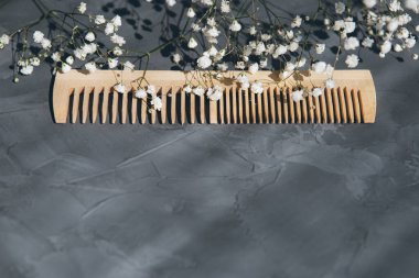 Gri arka planda doğal kullanışlı ahşap saç tarağı. Çevre dostu yaşam tarzı kavramı. Tonlama. Seçici odak.