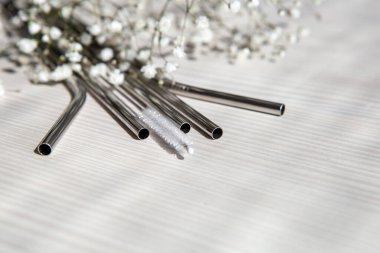 İçecekler için yeniden kullanılabilir metal pipetler ve beyaz arka planda temizlik fırçası. Çevre dostu yaşam tarzı kavramı. Tonlama. Seçici odak.