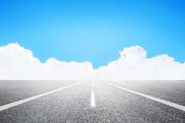 Estrada asfaltada sobre o céu azul com nuvens brancas fundo — Fotografia de Stock