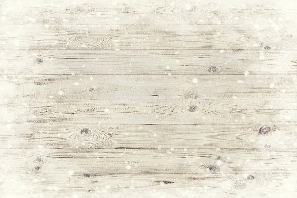 Die braune Holzstruktur mit Schneeflocken darüber. Winterlicher Hintergrund — Stockfoto