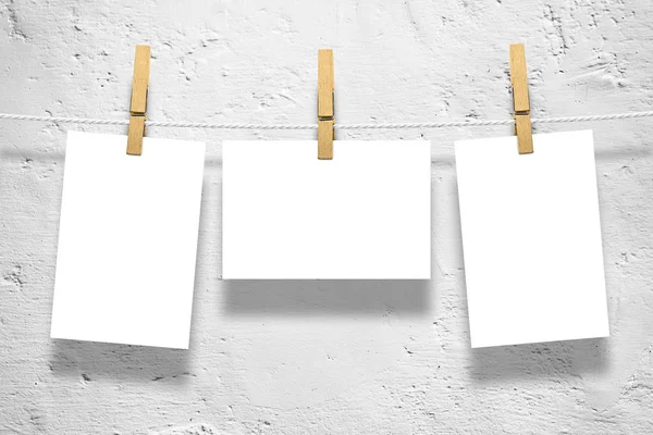 Photo frames with pins on rope over old aged white wall background — Stock Photo, Image