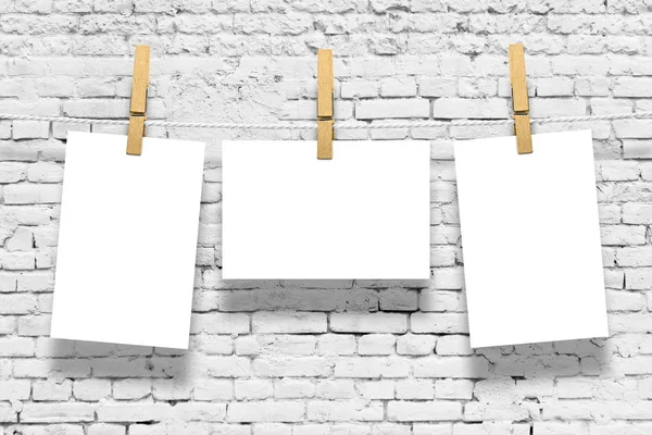 Photo frames with pins on rope over old aged brick wall background — Stock Photo, Image