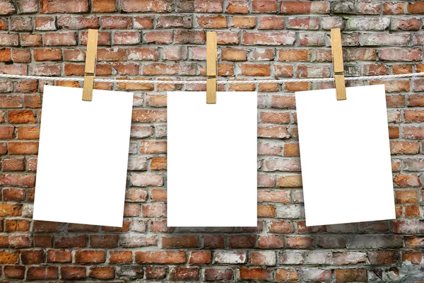 Photo frames with pins on rope over old aged brick wall background — Stock Photo, Image