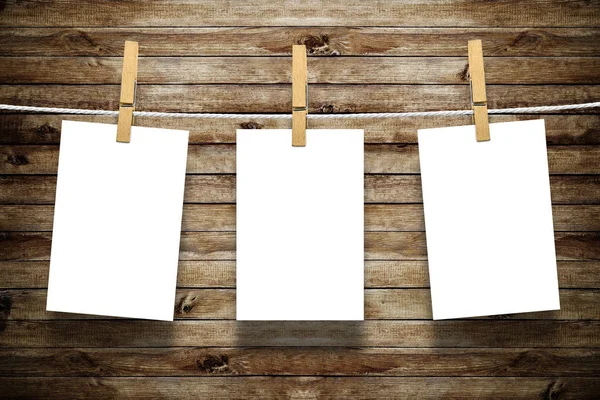 Photo frames with pins on rope over old aged wood wall background — Stock Photo, Image