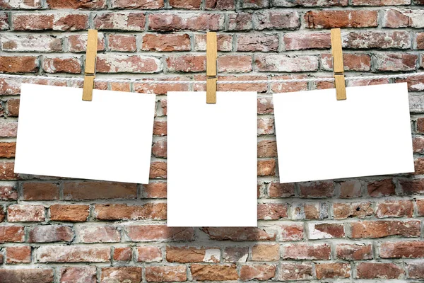 Photo frames with pins on rope over old aged brick wall background — Stock Photo, Image