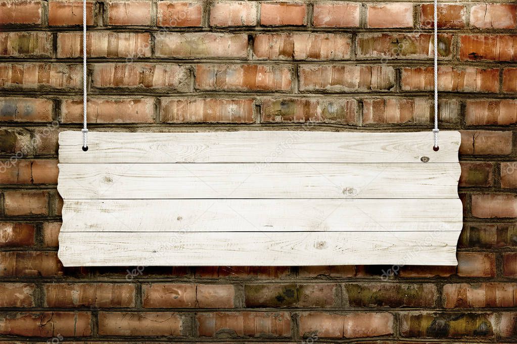 Wooden sign with ropes isolated over brick background