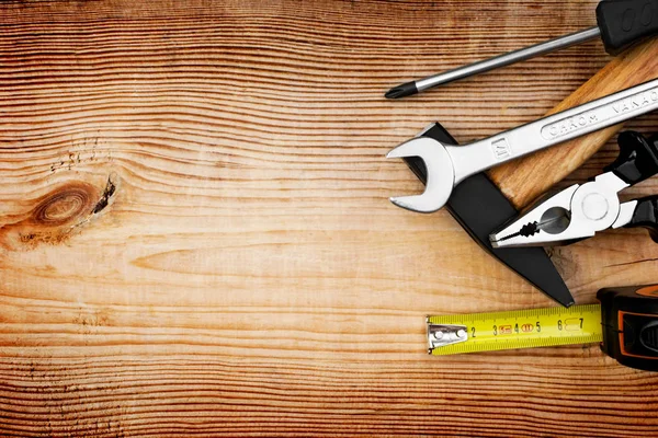 Fechar as ferramentas em um fundo de madeira — Fotografia de Stock