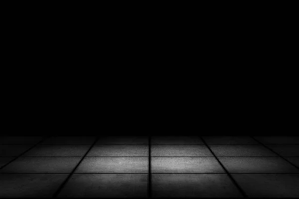 Темная комната с плиточным полом и черным фоном — стоковое фото