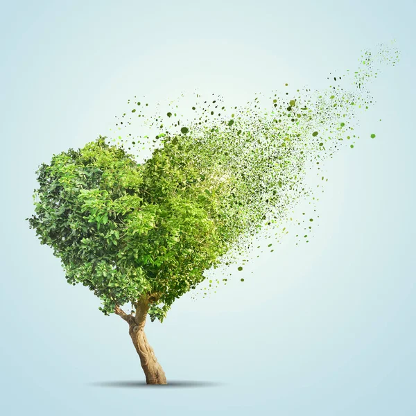 Green tree shaped in heart disintegrate over blue background — Stock Photo, Image