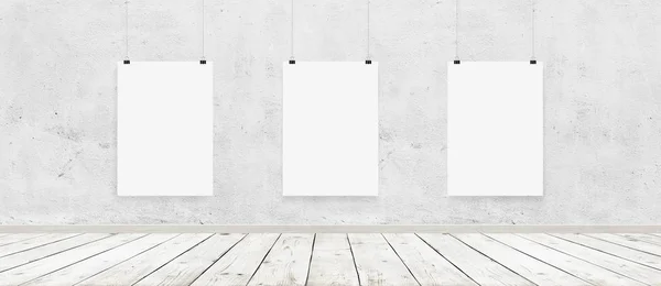 Tree vit blank affischer med bindemedel i inre med betongvägg och trägolv — Stockfoto