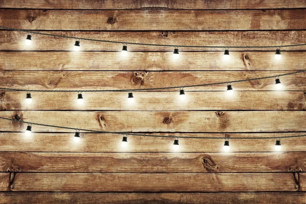 Lâmpadas de guirlanda sobre cerca de madeira. Decoração fundo — Fotografia de Stock