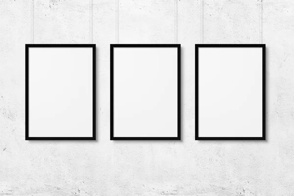 White blank photo frames mockup with ropes over white concrete wall background