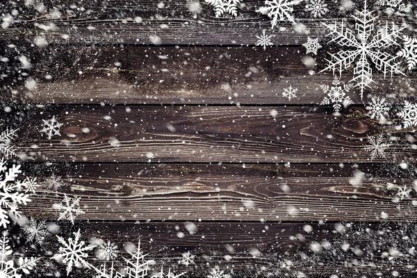 A textura de madeira marrom com flocos de neve sobre ele. Fundo de inverno — Fotografia de Stock
