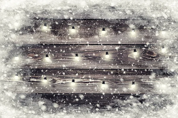 Die braune Holzstruktur mit Girlanden und Schneeflocken darüber. Hintergrund Weihnachtsurlaub — Stockfoto