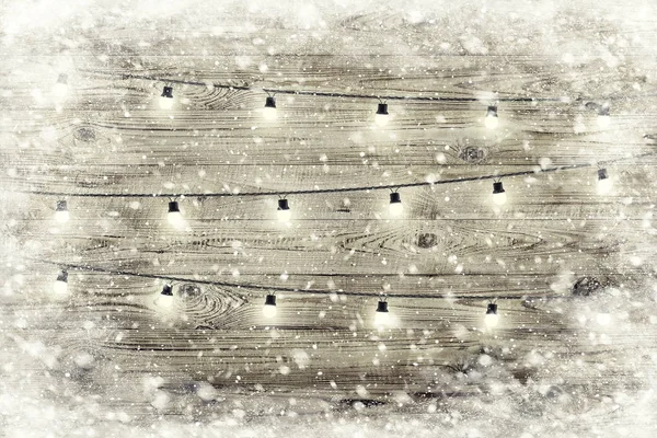 La textura de madera marrón con guirnalda y copos de nieve sobre ella . — Foto de Stock