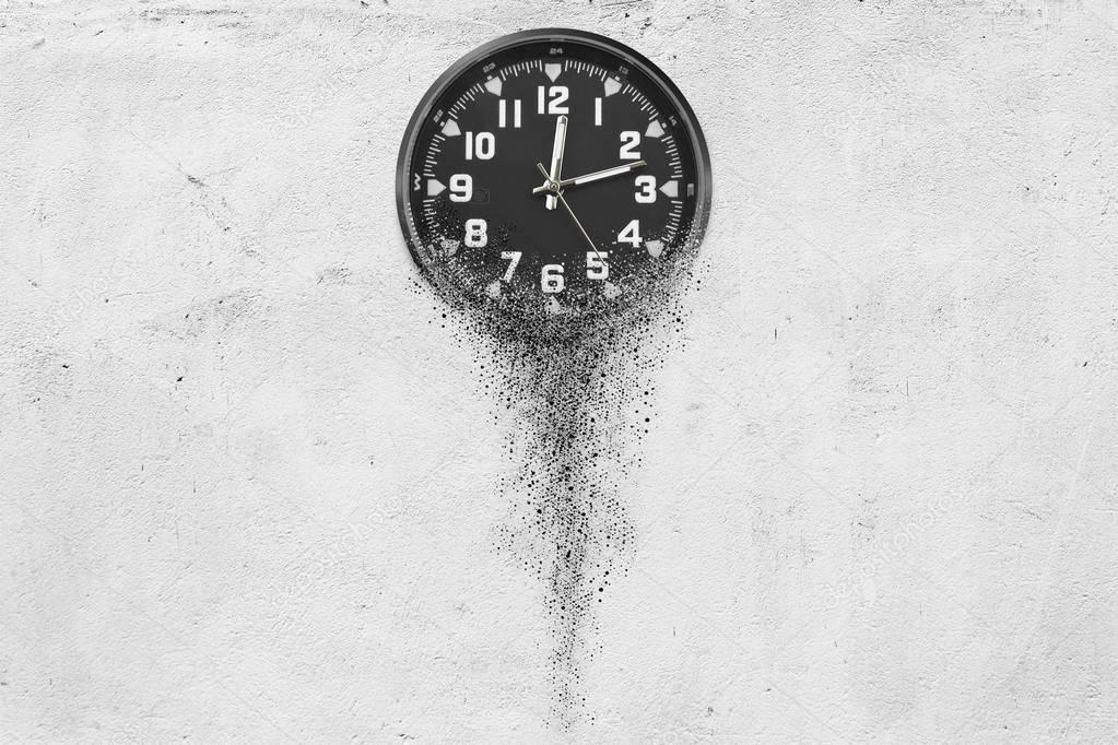 Classic clock on white concrete background disintegrate in a small parts and flowing away. Time flying concept