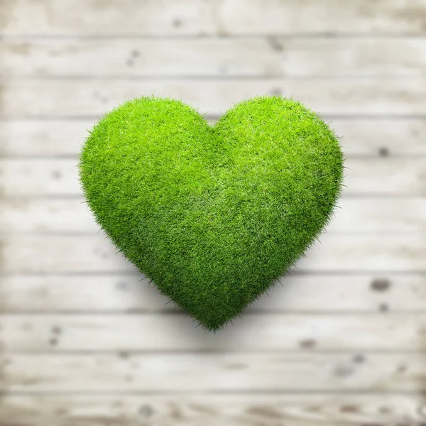 Forma de corazón de hierba verde sobre fondo de madera — Foto de Stock