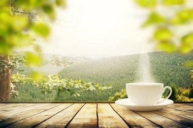 Dağların tepesinde çay fincanı ve güneş ışığı. Güzellik doğası