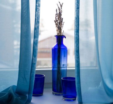 Natürmort mavi gözlük ve windowsi üzerinde bir vazo duran