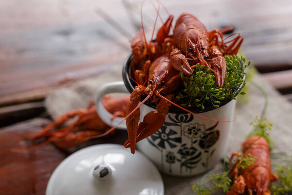 boiled crawfish, greens in the pan on a wooden table. Beer snack