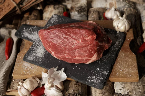 Carne fresca com faca no corte da placa preta, ainda vida em — Fotografia de Stock