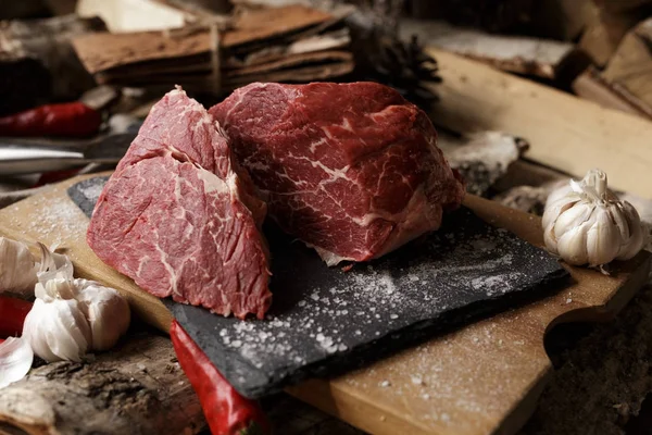 Carne fresca com faca no corte da placa preta, ainda vida em — Fotografia de Stock