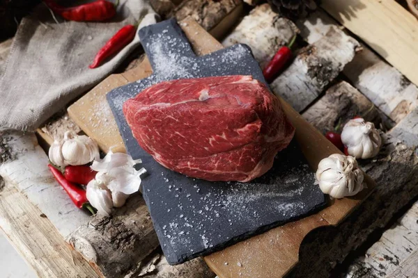 Carne fresca com faca no corte da placa preta, ainda vida em — Fotografia de Stock