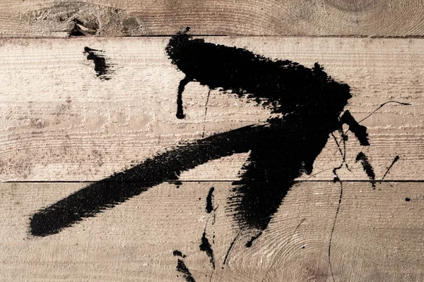 Arrow symbol, drawn in black paint on the wood surface. The indi — Stock Photo, Image