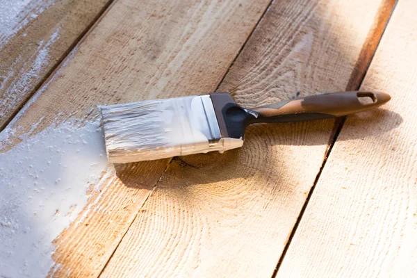 ahşap arka plan üzerinde beyaz boya ile fırça. ahşap boyama