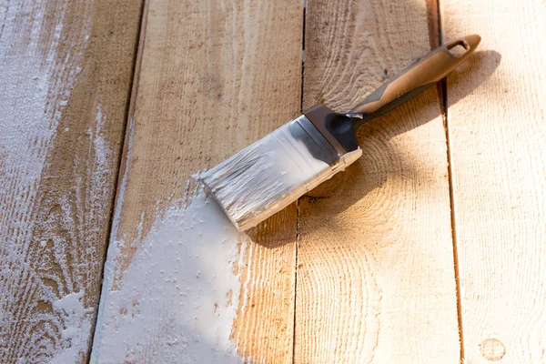 ahşap arka plan üzerinde beyaz boya ile fırça. ahşap boyama
