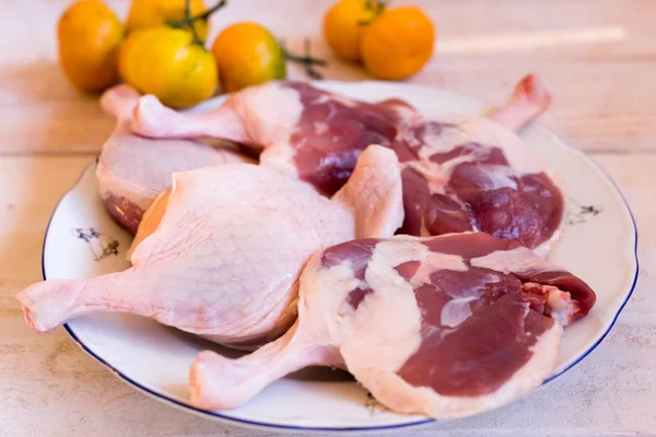 duck meat fresh, raw duck legs with fruit on a wooden surface.