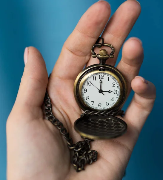 vintage old watch on a chain. hand holding a watch on a chain.
