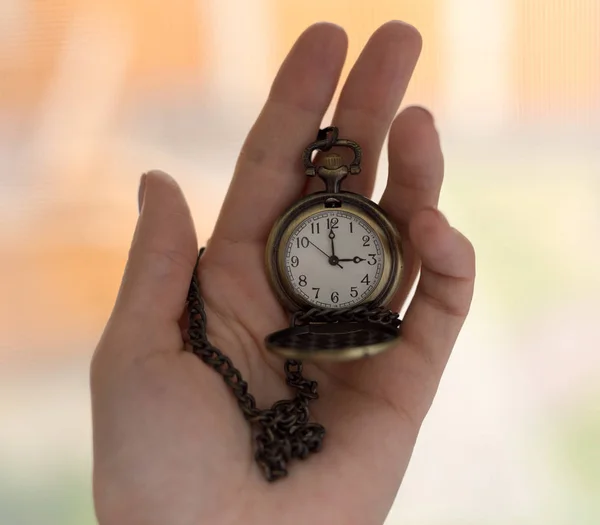 Vecchio orologio d'epoca su una catena. mano che tiene un orologio su una catena . — Foto Stock