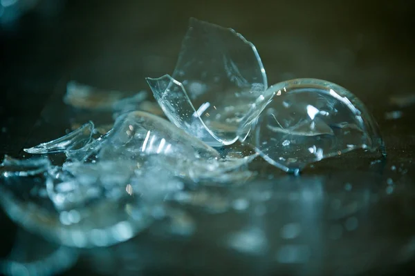 broken glass against grey background, concept of danger