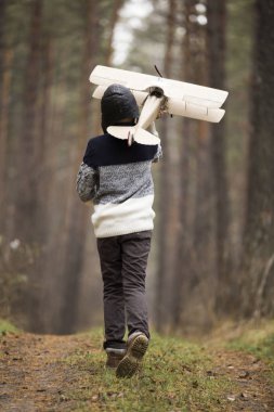 bir çocuk oyuncak uçak ile ormanda çalış. w sonbahar oyunları