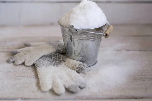 Sneeuw in een emmer met handschoenen, bedekt met sneeuw. — Stockfoto