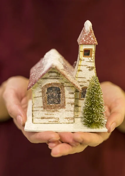 Christmas toy in a female hand. toy tree house. Stock Photo