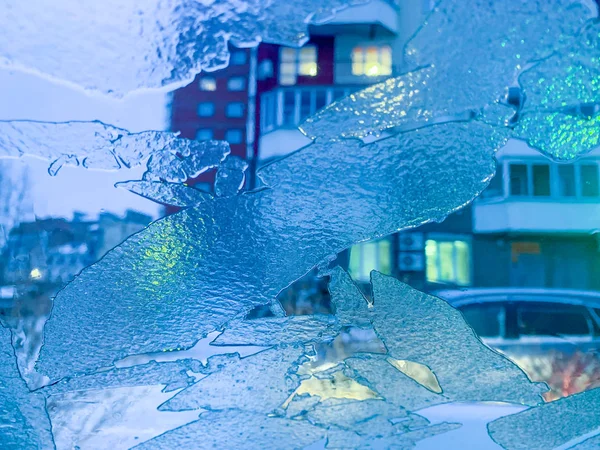 Suddig bakgrund frusen från isfönsterglas med ljus — Stockfoto