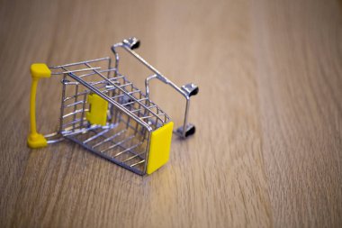 Masanın ahşap yüzeyinde alışveriş arabası devrilmiş.