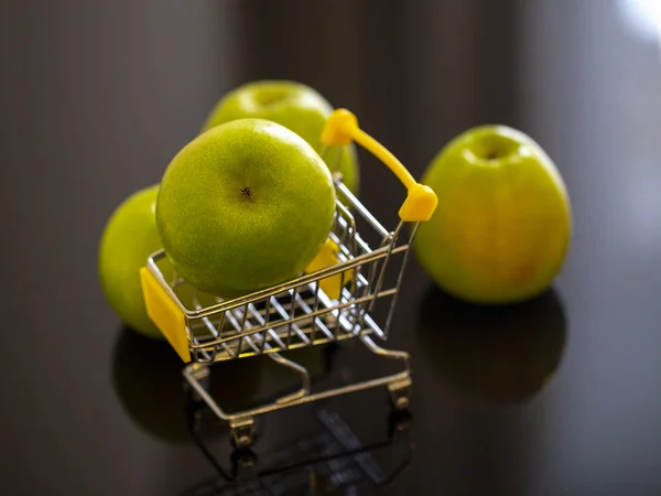 Ένα Πράσινο Μήλο Ένα Καροτσάκι Για Ψώνια Concept Φωτογραφία — Φωτογραφία Αρχείου