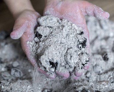 Bir çocuğun elinde yanmış küller. Yaklaş.