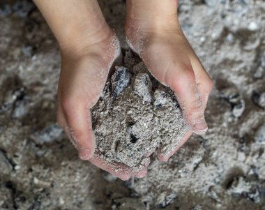 Bir çocuğun elinde yanmış küller. Yaklaş.