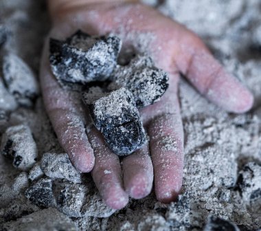 Bir çocuğun elinde yanmış küller. Yaklaş.